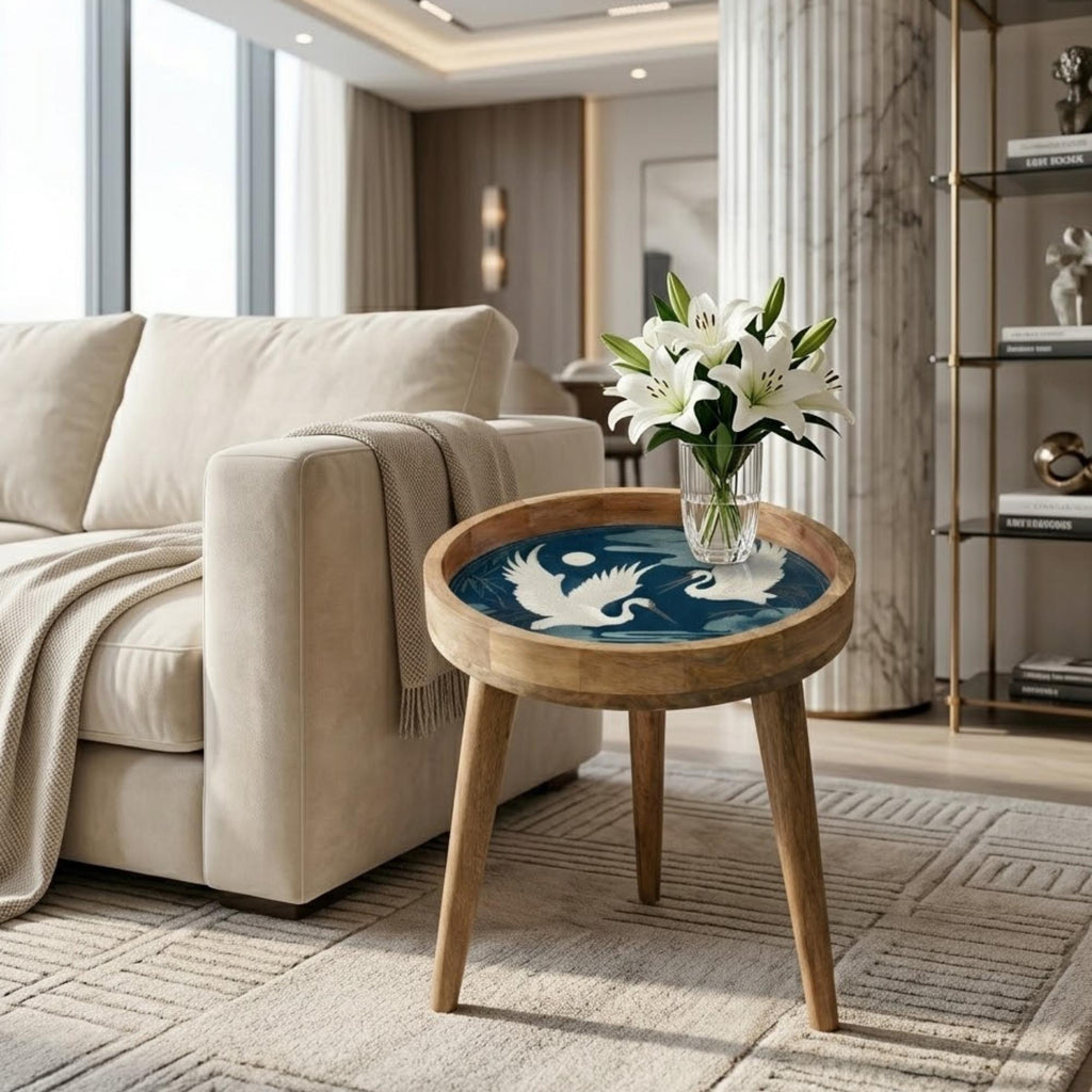Crane Bird Mango Wood Side Table, shown beside a sofa in a styled room.