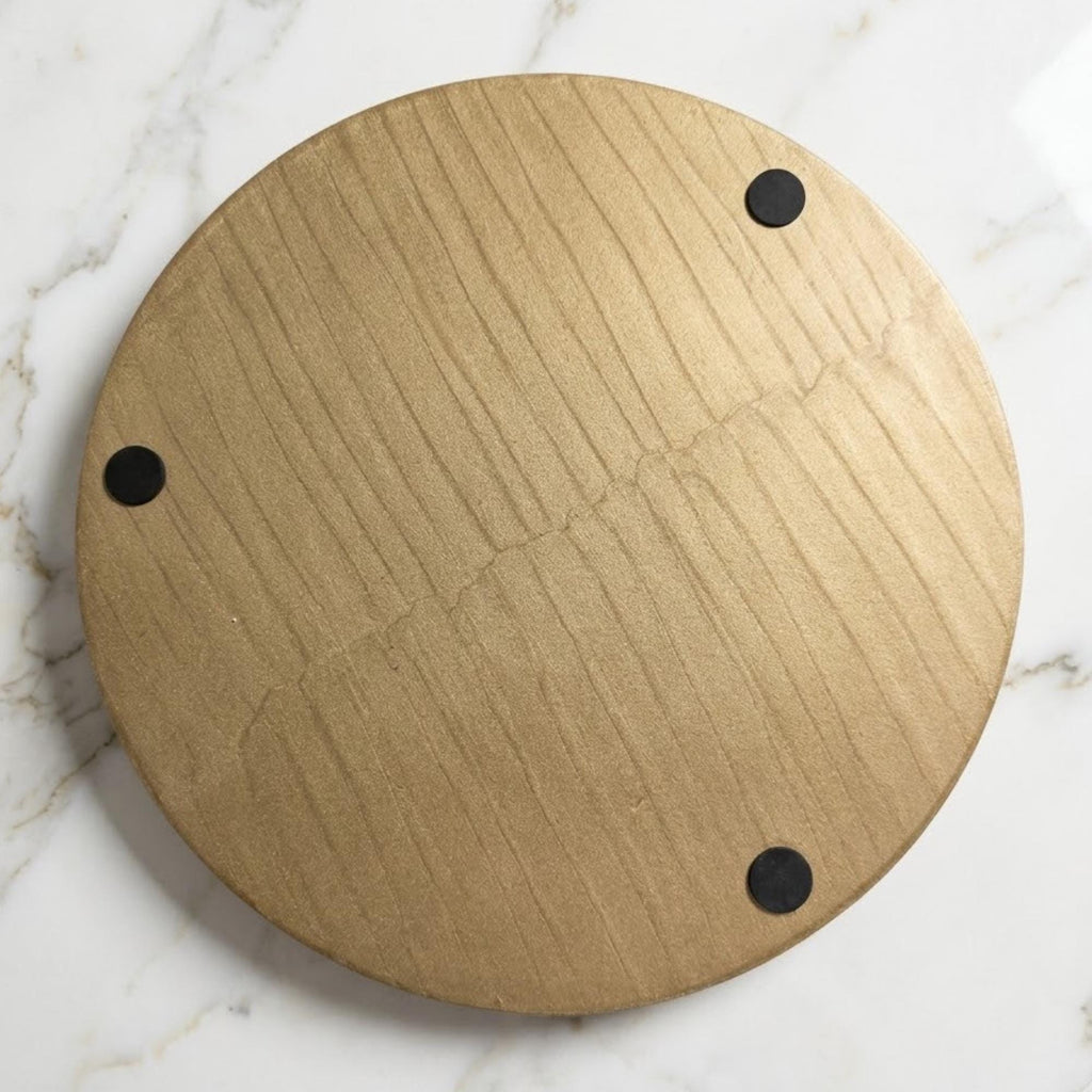 Woodgrain underside of the round serving tray with protective pads.