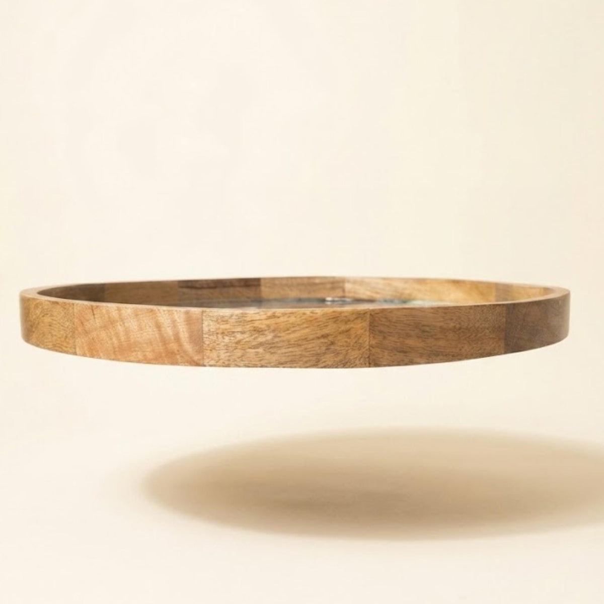 Side profile of the round wooden tray showing its raised rim.